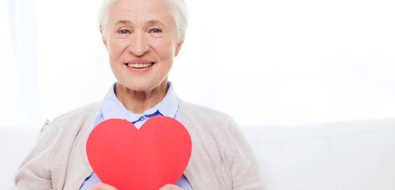 photo de grand-mère tenant un coeur rouge dans la main