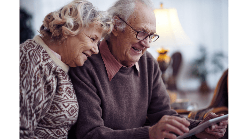 Des grands-parents sourient devant une tablette