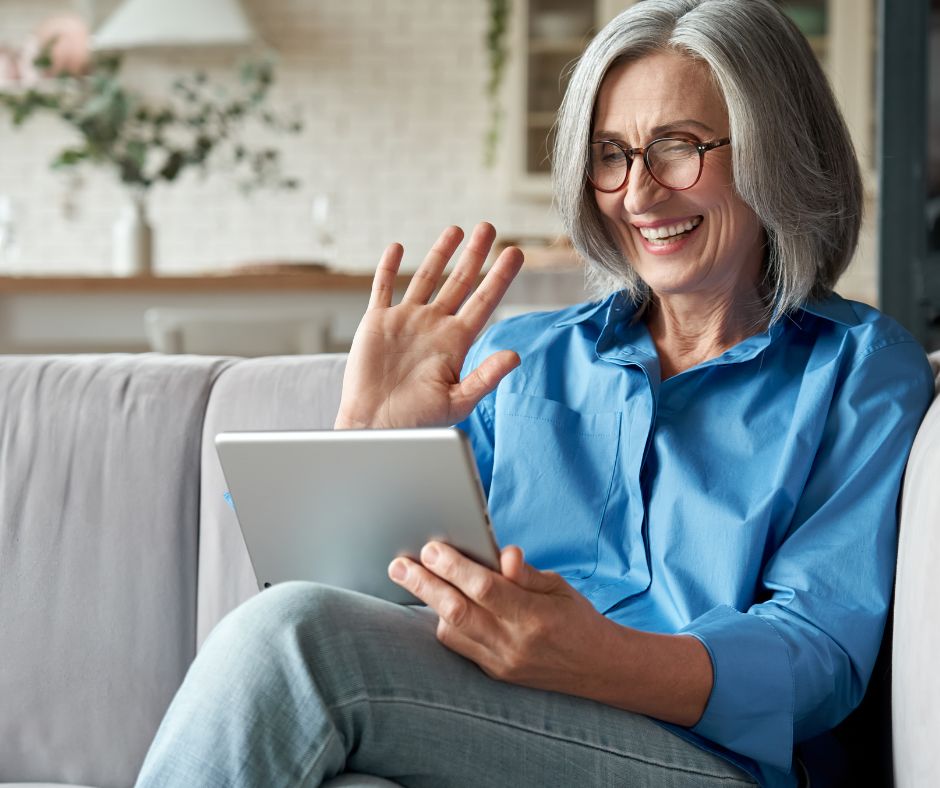 grand-mère qui fait coucou avec une tablette