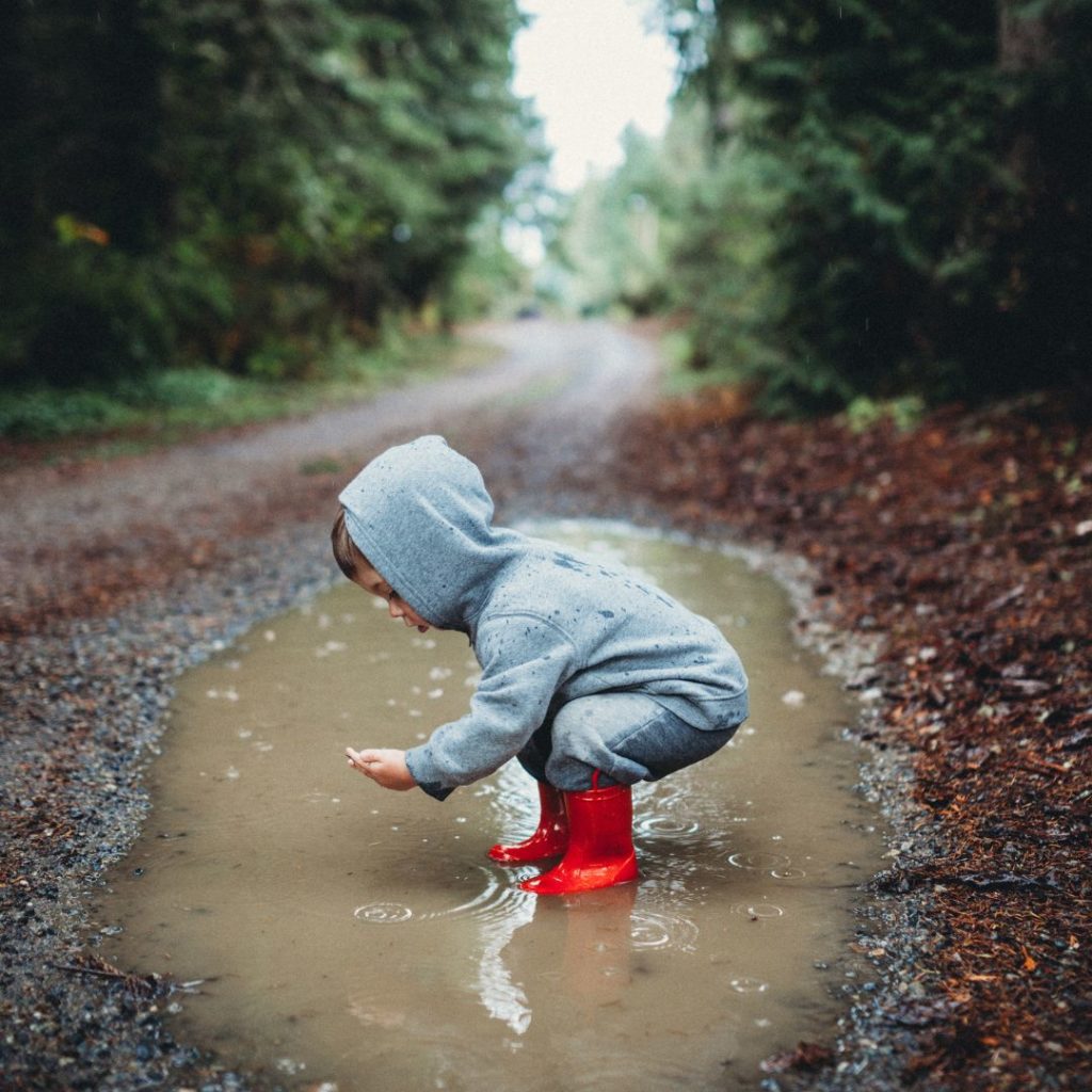 enfant dans une flaque d'eau